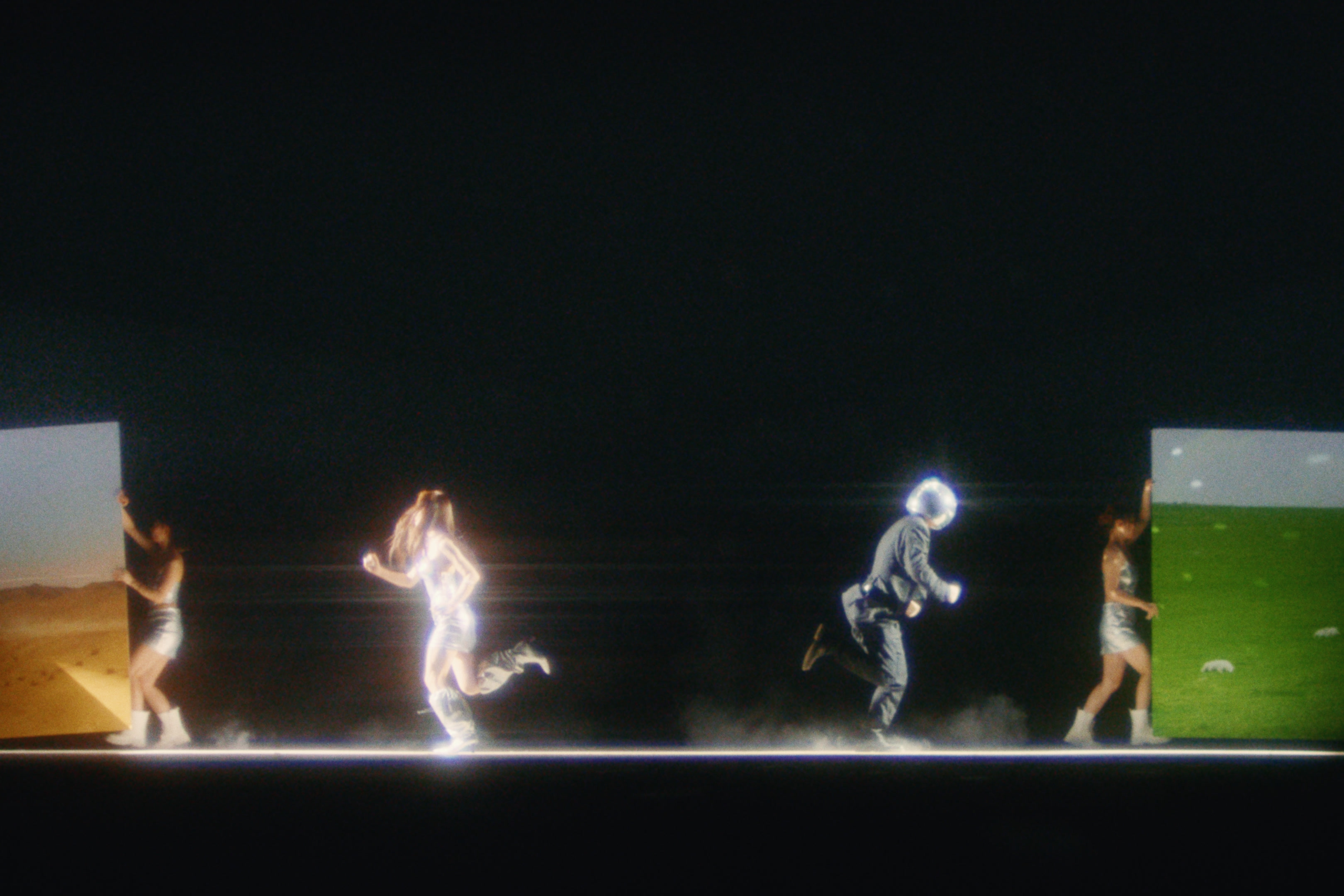 Figures running between painted landscapes on a dark stage