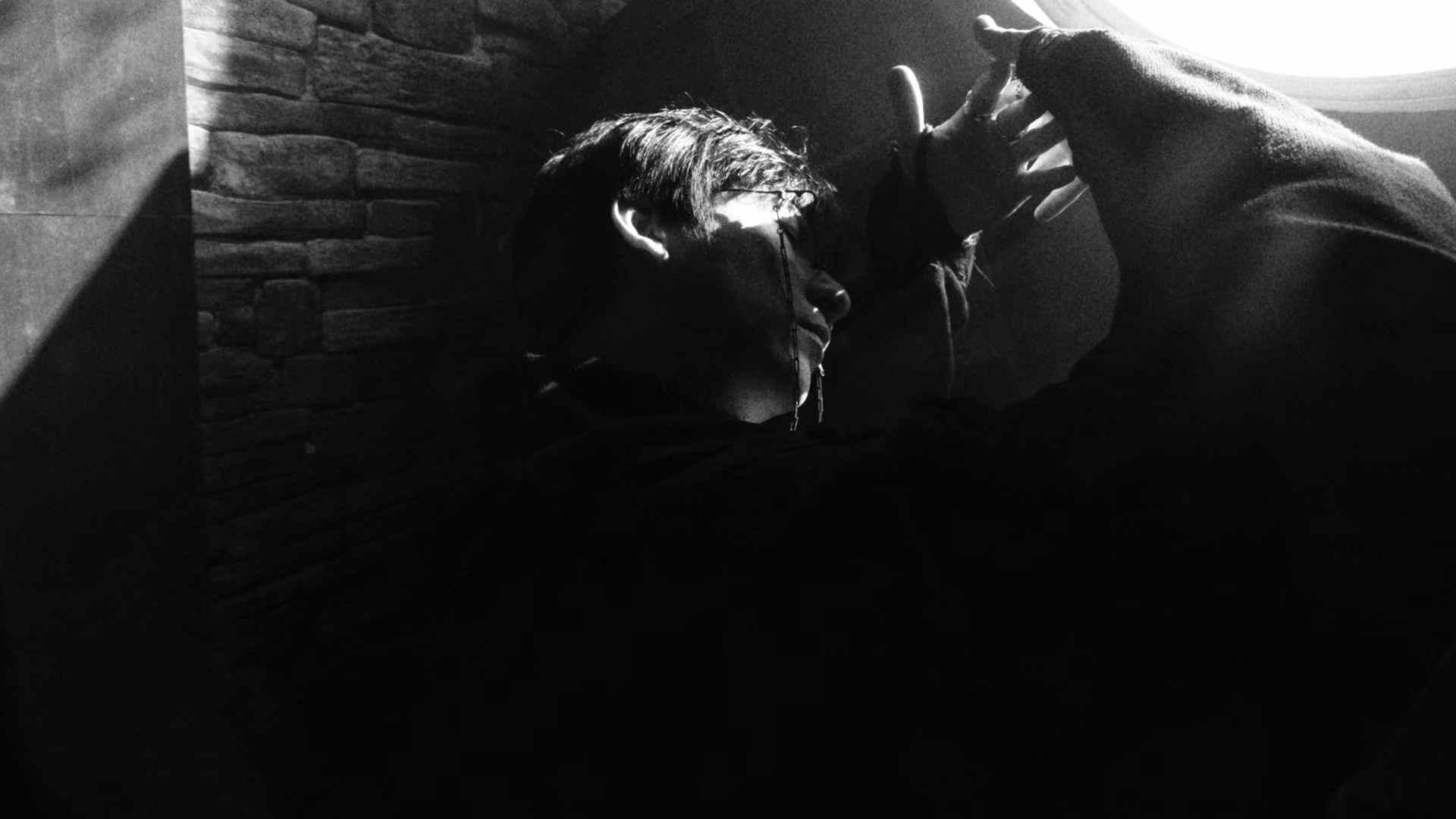 Sean Tang reaching toward a bright circular light