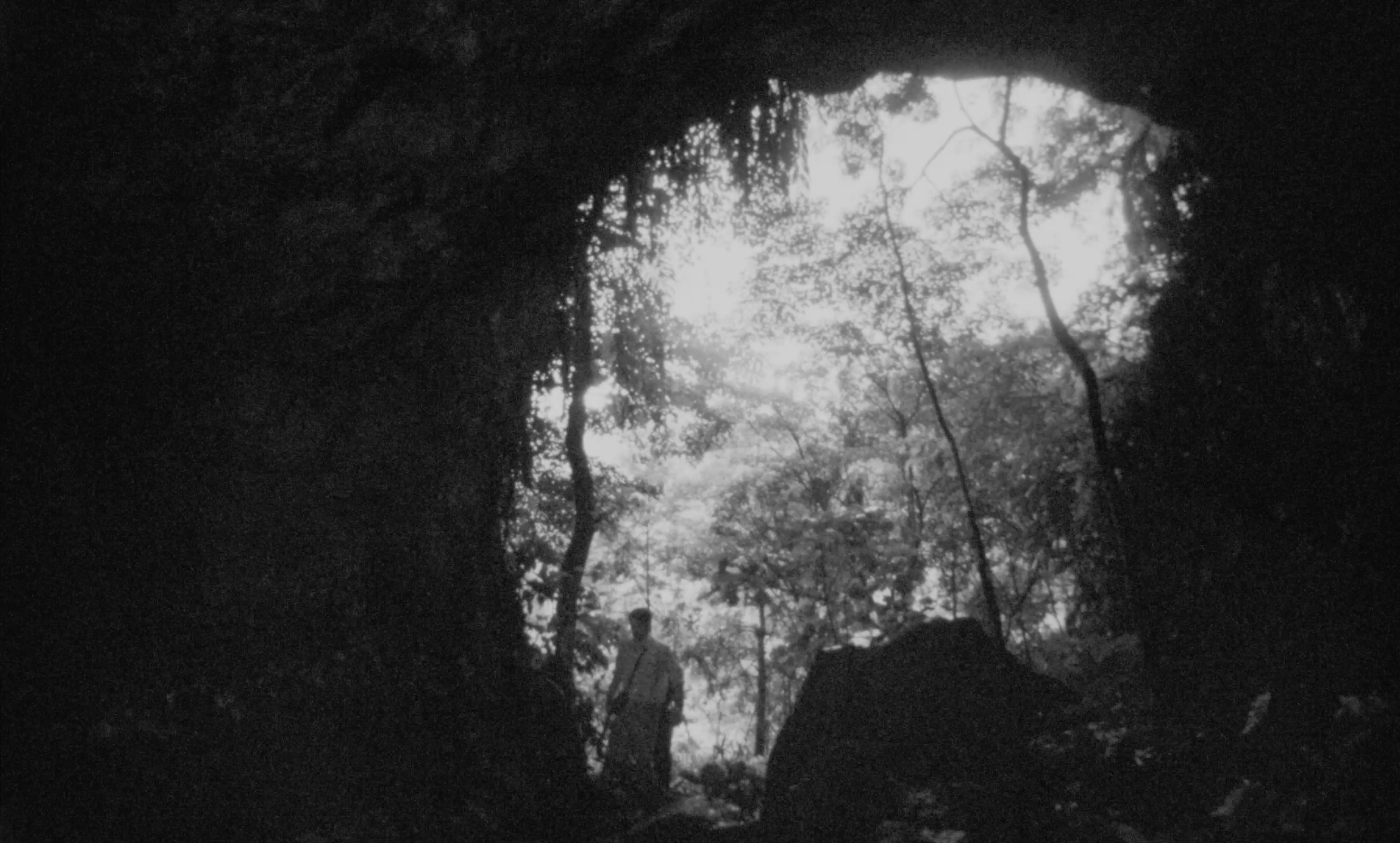 A figure at the mouth of a cave