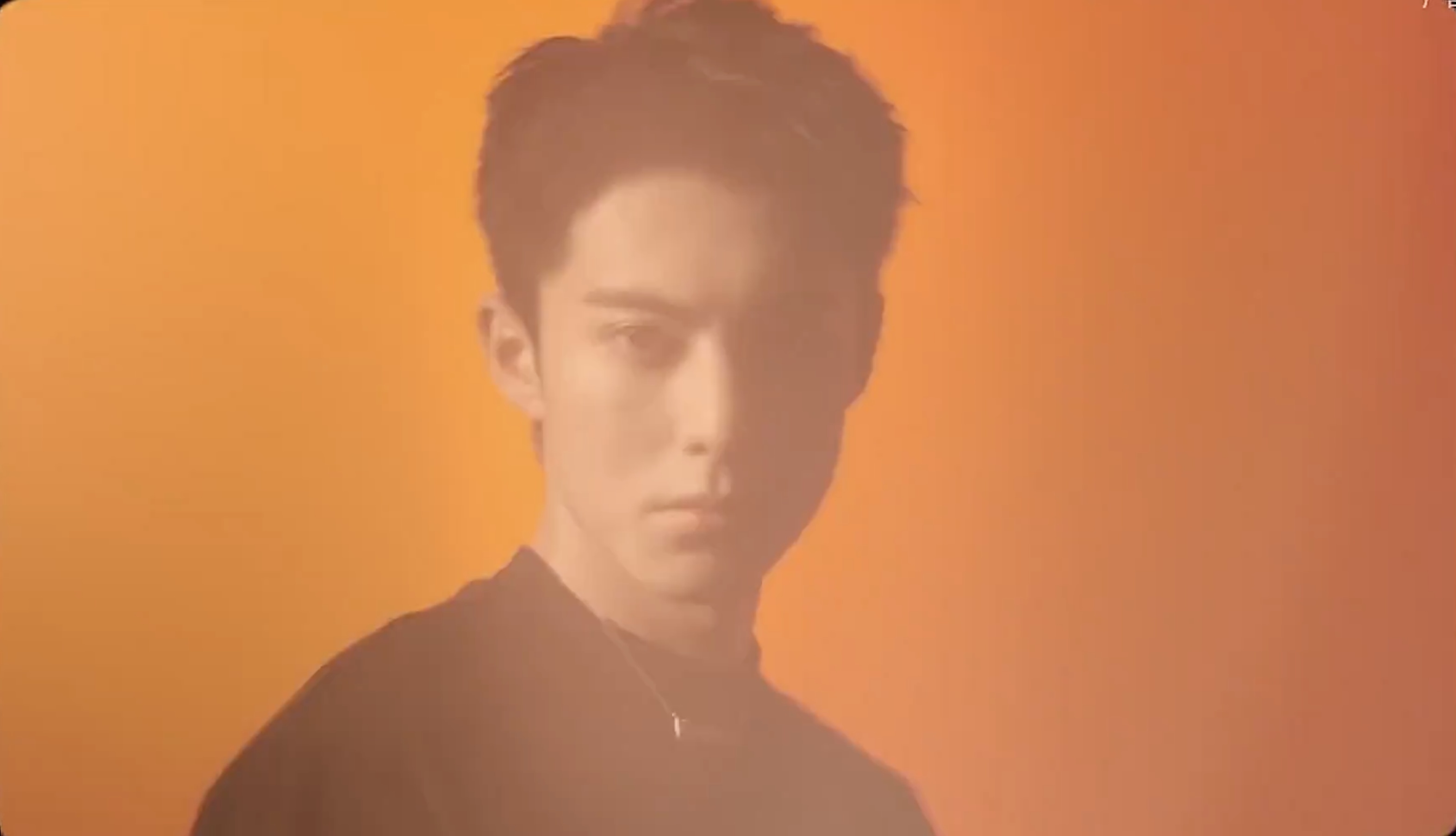 A portrait against warm orange light