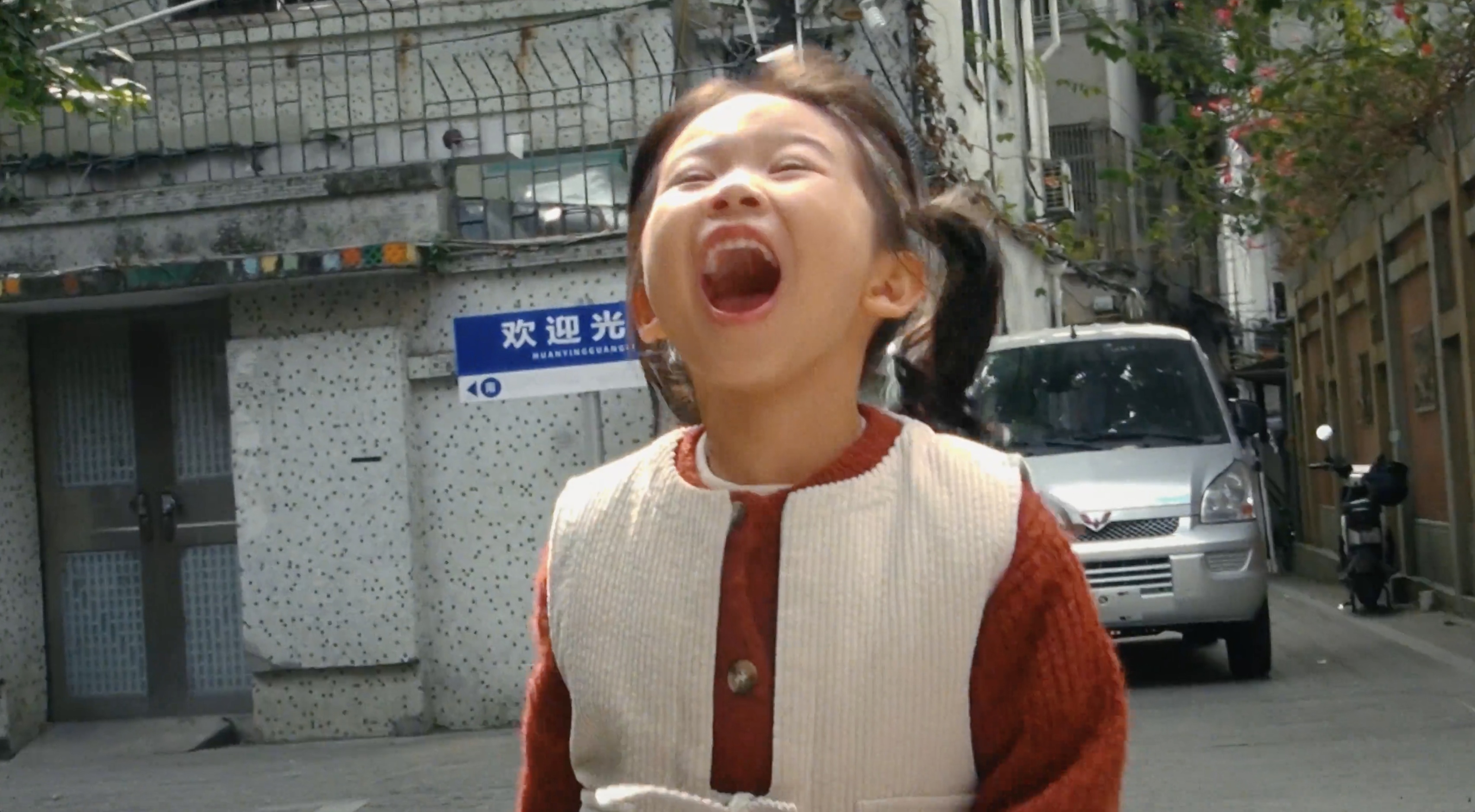A child laughing in a neighbourhood street