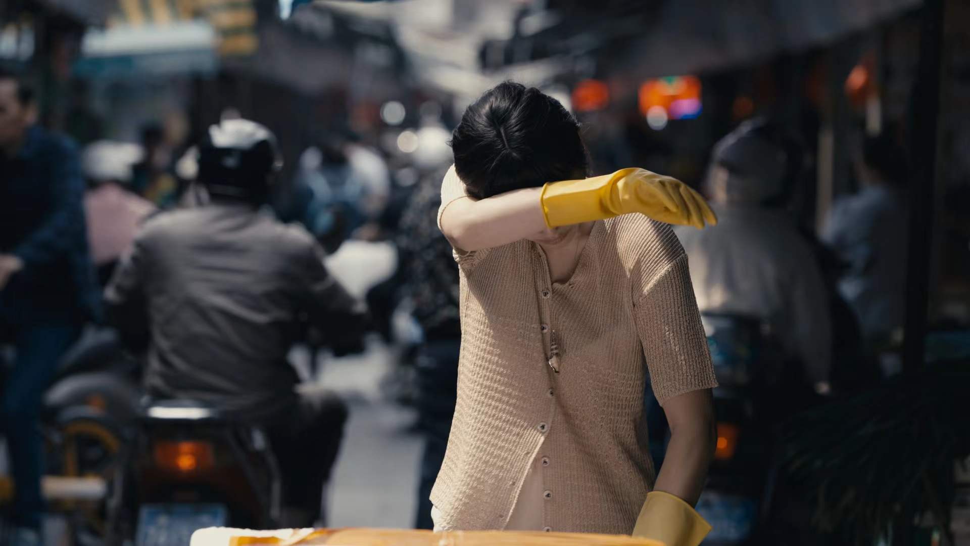 A woman wearing yellow gloves in a busy street
