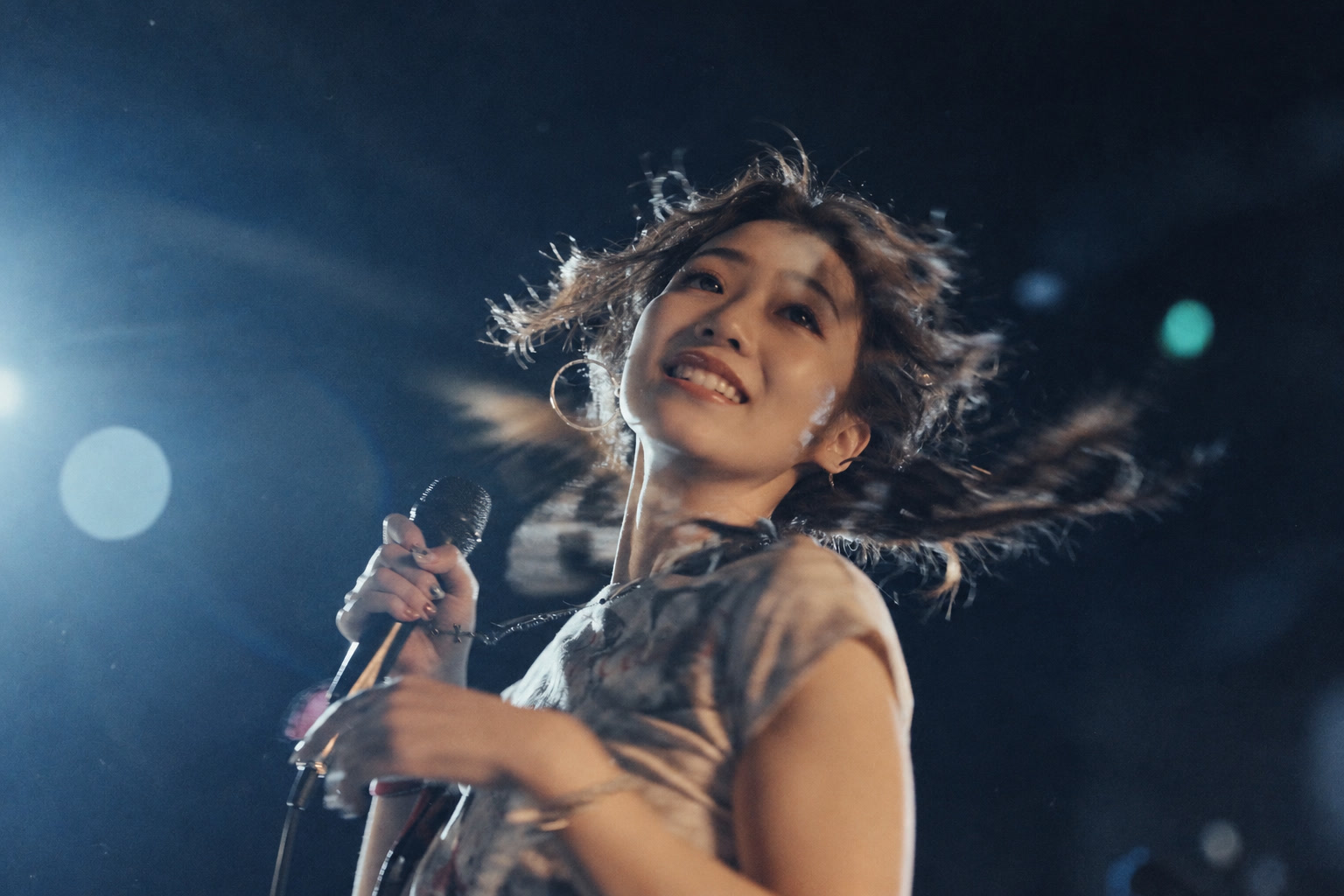 NATIONAL STADIUM | K FIRST — a woman holding a microphone