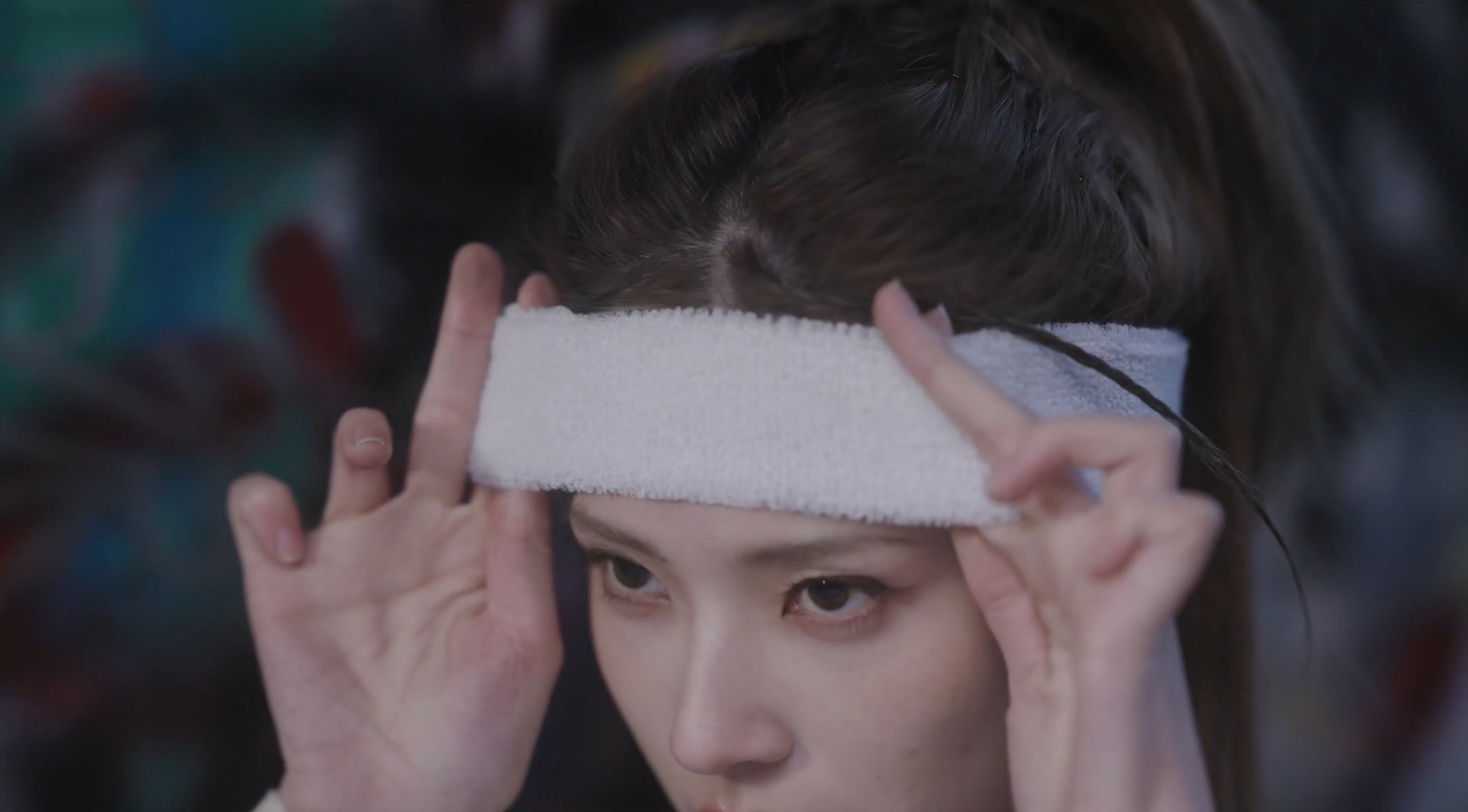 A woman adjusting a white sports headband