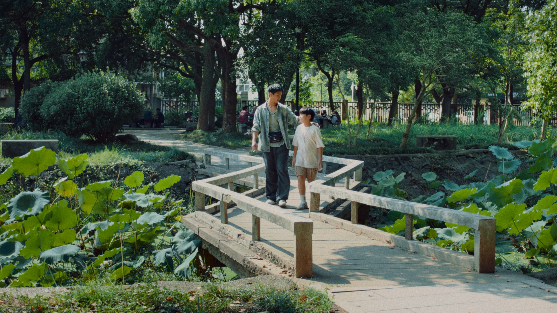 A man and boy on a park bridge