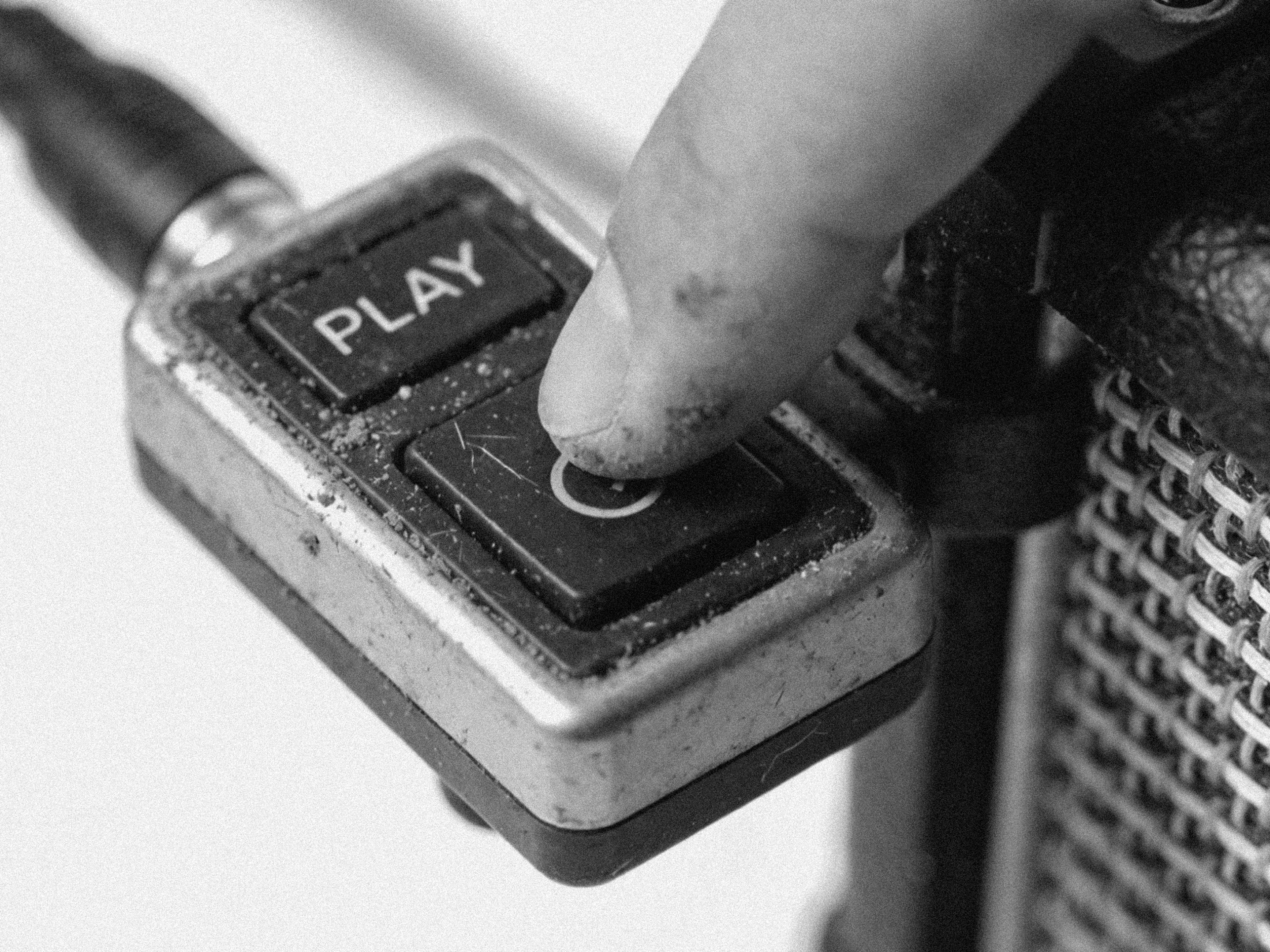 A finger pressing the play button